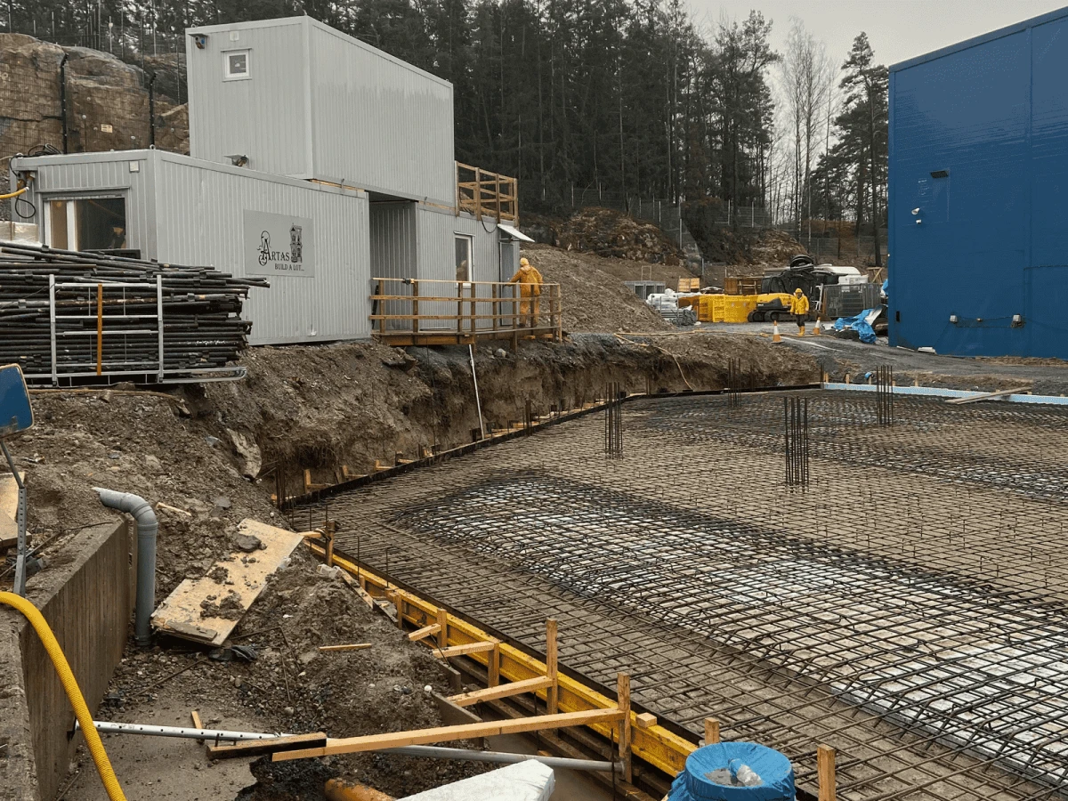 Bilden visar schaktning och isolering av grunden i Dustcontrol-projektet. Här förbereder vi marken och lägger grundisolering inför armering och gjutning av den stora industriplattan.