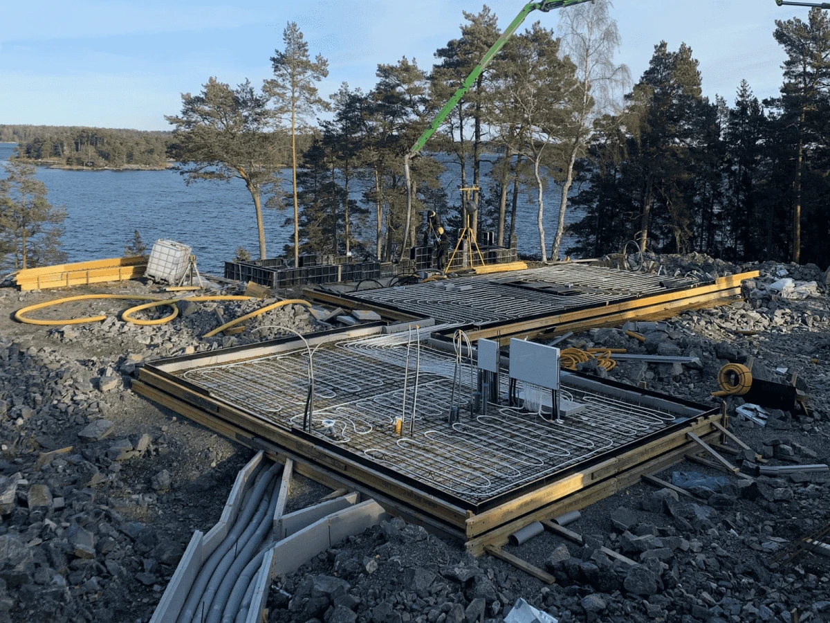Vi utförde ett enormt och mycket komplext markarbete – sprängning av över 1 100 m² berg till ett djup på cirka 3 meter för att möjliggöra byggnationen av en ny, exklusiv semestervilla på Djurö. Under projektets gång skapade vi även en oplanerad källare: ett teknikutrymme med överströmnings­tank för en infinity-pool.

De avancerade markarbetena, tillsammans med produktionen av flera fristående och uppvärmda plattor på mark samt installation av alla anslutningar och tekniska system, var en omfattande utmaning. Utöver detta ledde vi hela byggnationen vidare – ända fram till nyckelfärdigt hus.

Detta projekt är ett av de mest intressanta och krävande vi någonsin har genomfört, och det kommer för alltid att ha en särskild plats i våra hjärtan.
